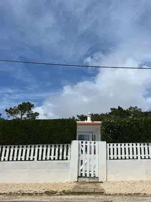 a white fence with a white gate and a lighthouse at Casa de Maio - New T2 - ARRIFANA BEACH 650 mts in Aljezur