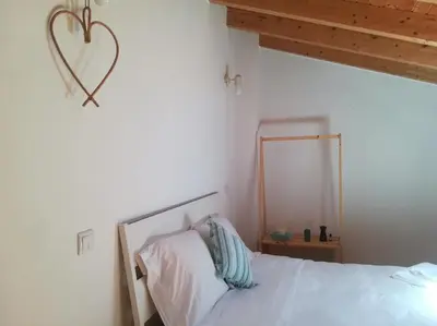 a bedroom with a bed with a heart on the wall at Studio Rufia in Vila do Bispo