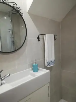 a white bathroom with a sink and a mirror at Studio Rufia in Vila do Bispo