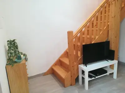 a living room with a tv and a staircase at Studio Rufia in Vila do Bispo