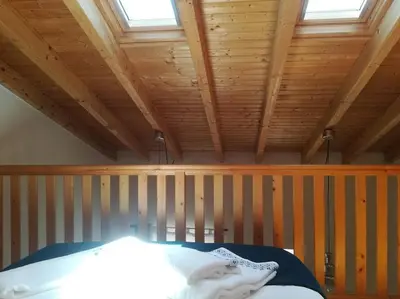 a bedroom with a wooden ceiling with a bed in it at Studio Rufia in Vila do Bispo
