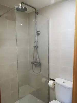 a bathroom with a glass shower with a toilet at Studio Rufia in Vila do Bispo