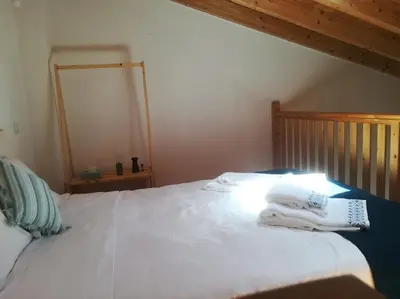 a bedroom with a white bed with towels on it at Studio Rufia in Vila do Bispo