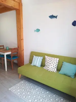 a green couch in a living room with a table at Studio Rufia in Vila do Bispo