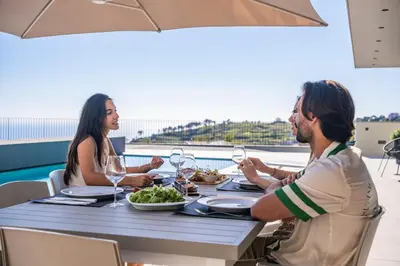 a group of people sitting at a table with wine glasses at Villa Elysian Oasis by Homie in Fajã da Ovelha