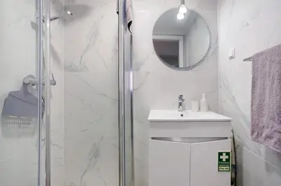 a bathroom with a shower and a sink and a mirror at Família Dória Nóbrega T0 in Funchal