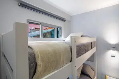 a bedroom with a bunk bed and a mirror at Família Dória Nóbrega T0 in Funchal