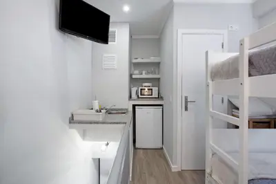 a kitchen with white cabinets and a table with a plate of food at Família Dória Nóbrega T0 in Funchal