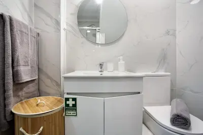 a white bathroom with a sink and a mirror at Família Dória Nóbrega Estúdio in Funchal
