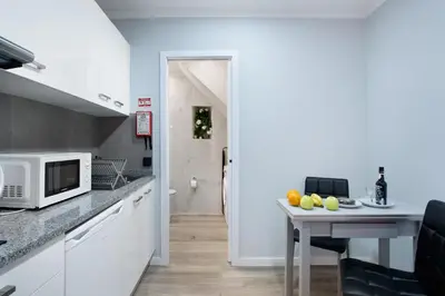 a kitchen with a table and a microwave at Família Dória Nóbrega Estúdio in Funchal