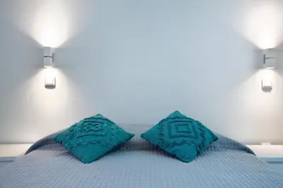 a bed with two blue pillows on top of it at Família Dória Nóbrega Estúdio in Funchal