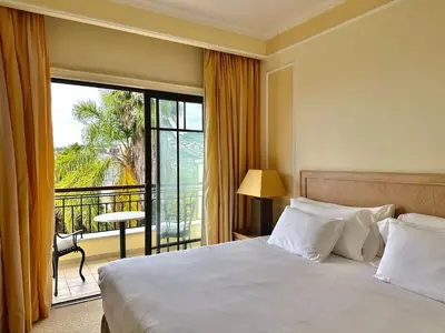 a hotel room with a bed and a balcony at Quinta Funchal Gardens - Adults Only in Funchal