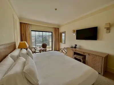 a hotel room with a large bed and a television at Quinta Funchal Gardens - Adults Only in Funchal