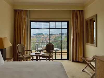 a hotel room with a bed and a large window at Quinta Funchal Gardens - Adults Only in Funchal