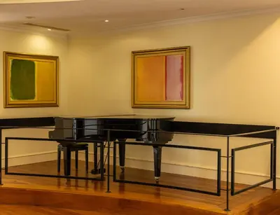 a piano in a room with paintings on the wall at Quinta Funchal Gardens - Adults Only in Funchal