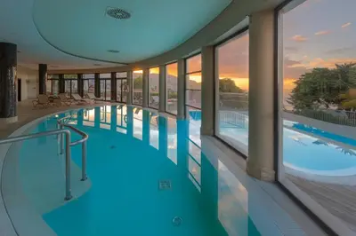a swimming pool in a building with a view at Quinta Funchal Gardens - Adults Only in Funchal