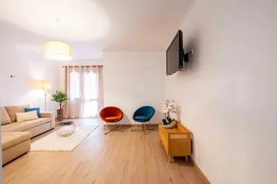 a white bedroom with a bed and a rug at Casa do Neves in Funchal
