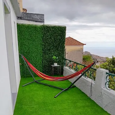 a hammock on a balcony with a green wall at Casa D'Avó Filó in Funchal