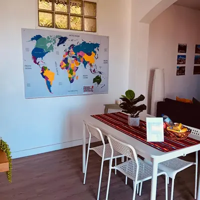 a white table with chairs and a world map on the wall at Casa D'Avó Filó in Funchal