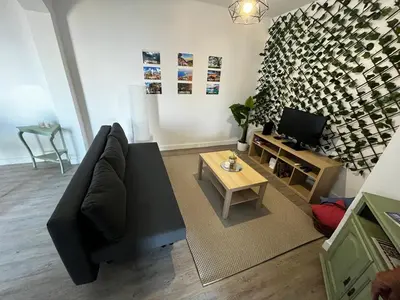 a living room with a black couch and a tv at Casa D'Avó Filó in Funchal