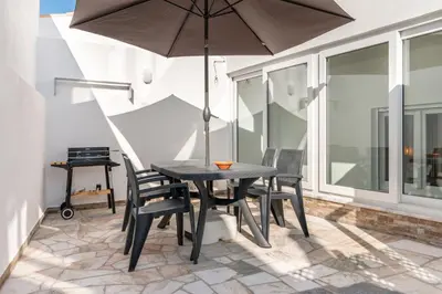 a table and chairs with an umbrella on a patio at Casa Cintra in Almádena