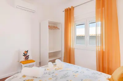 a bedroom with a bed with an orange curtain at Casa Cintra in Almádena