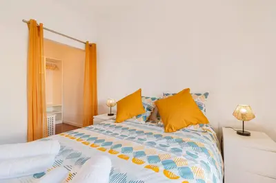 a bedroom with a large bed with yellow pillows at Casa Cintra in Almádena