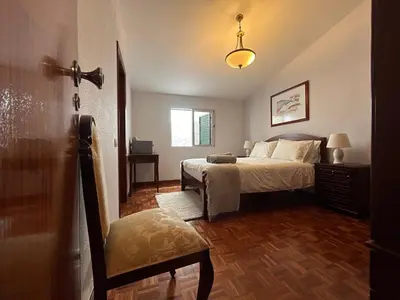 a bedroom with a bed and a chair in it at Vila Pico da Torre Apartment in Câmara de Lobos