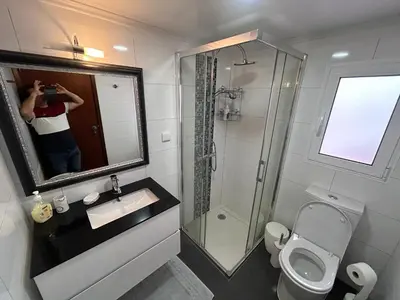 a person taking a picture of a bathroom at Vila Pico da Torre Apartment in Câmara de Lobos