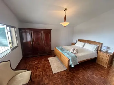 a bedroom with a bed with a dog laying on it at Vila Pico da Torre Apartment in Câmara de Lobos
