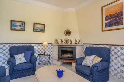 a living room with two chairs and a fireplace at Vila Telo in Luz