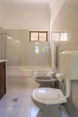 a white bathroom with a toilet and a sink at Vila Telo in Luz