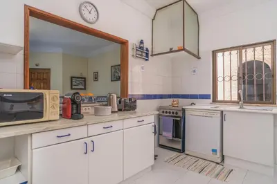 a kitchen with white appliances and a clock on the wall at Vila Telo in Luz