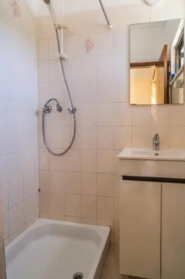 a bathroom with a bath tub and a sink at Vila Telo in Luz