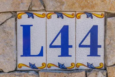 a blue and white sign on a stone wall at Vila Telo in Luz