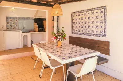 a kitchen and dining room with a table and chairs at Vila Telo in Luz