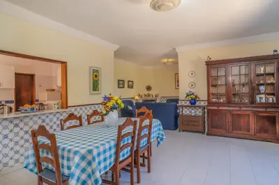 a dining room with a table and a kitchen at Vila Telo in Luz
