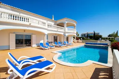 a villa with a swimming pool and lounge chairs at Parque da Floresta villa 209 with pool on golf resort in Budens