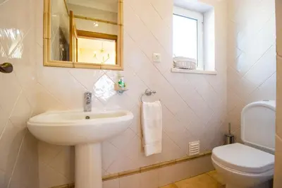 a bathroom with a sink and a toilet and a mirror at Parque da Floresta villa 209 with pool on golf resort in Budens
