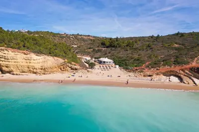 an aerial view of a beach with people on it at Parque da Floresta villa 209 with pool on golf resort in Budens