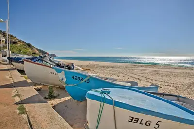 a row of boats sitting on the beach at Parque da Floresta villa 209 with pool on golf resort in Budens
