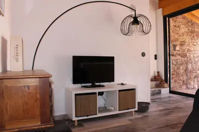 a tv sitting on a stand in a living room at Casa da Figueira - Guest House in Figueira