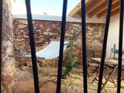 a hammock hanging from a stone wall in a patio at Casa da Figueira - Guest House in Figueira