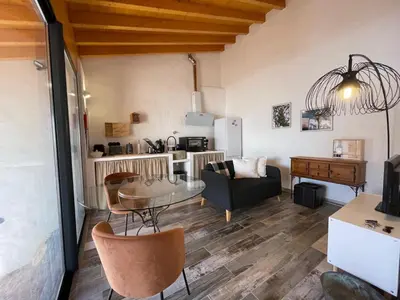a living room with a table and a kitchen at Casa da Figueira - Guest House in Figueira