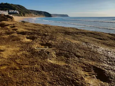 a rocky beach with the ocean in the background at Casa da Figueira - Guest House in Figueira