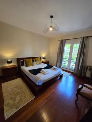 a bedroom with a large bed and a large window at TMaria in Ponta do Sol