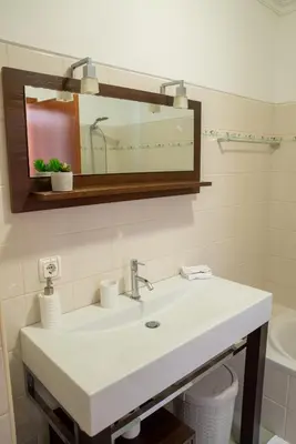 a bathroom with a white sink and a mirror at TMaria in Ponta do Sol