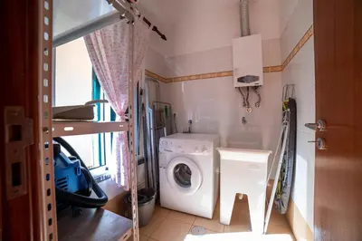a laundry room with a washing machine and a washer at TMaria in Ponta do Sol