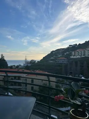 a balcony with a view of the ocean and buildings at TMaria in Ponta do Sol