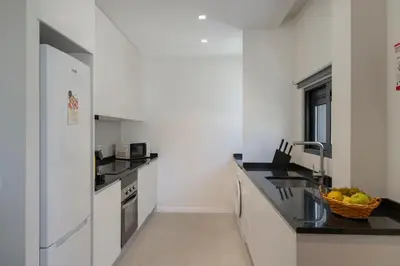a white kitchen with a sink and a counter at Golden City by An Island Apart in Funchal